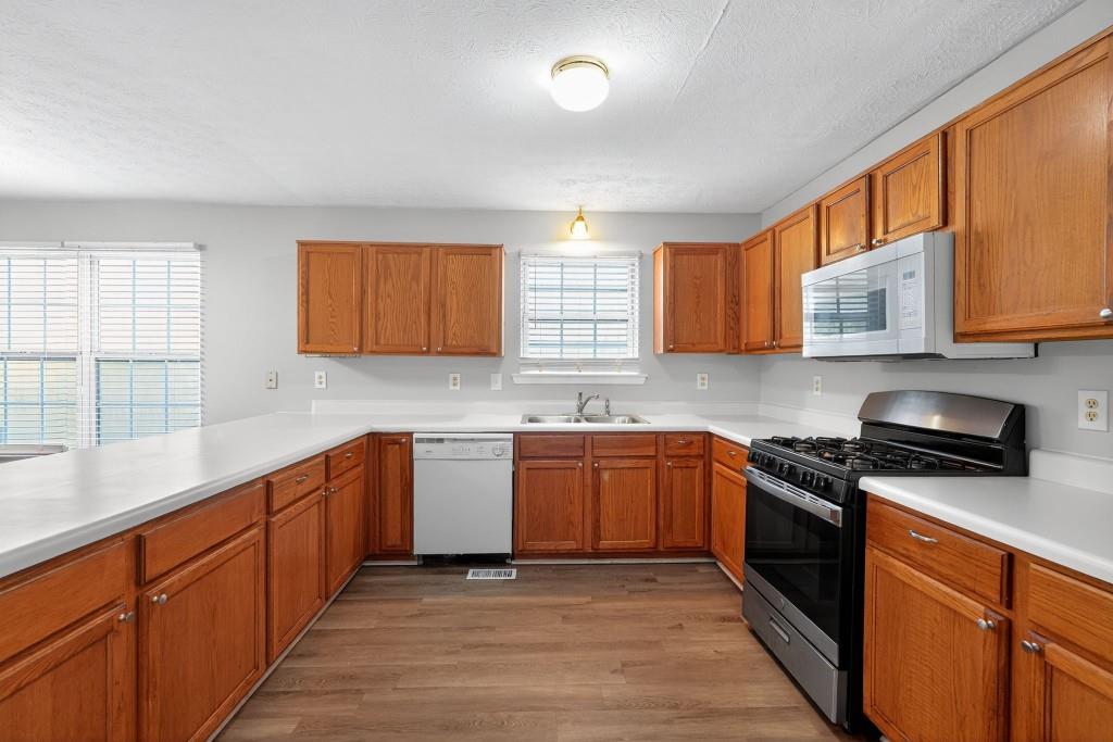 3737 Waldrop Road Decatur, GA 30034 - Photo 2 of 23 a kitchen with stainless steel appliances granite countertop wooden cabinets a stove top oven a sink and dishwasher with wooden floor