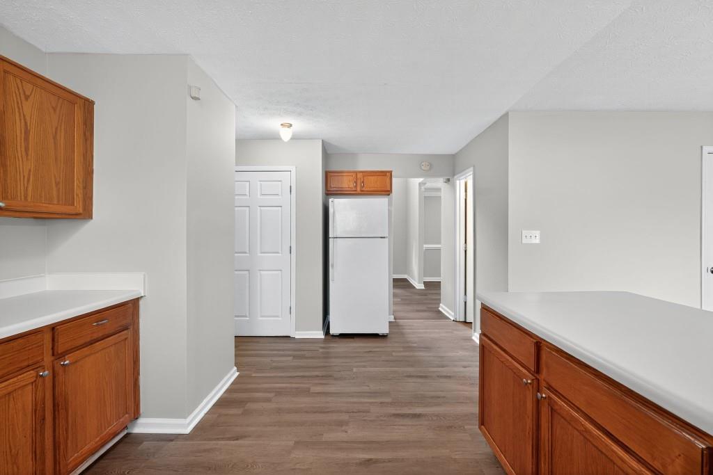 3737 Waldrop Road Decatur, GA 30034 - Photo 9 of 23 a view of a refrigerator in kitchen and an empty room with wooden floor