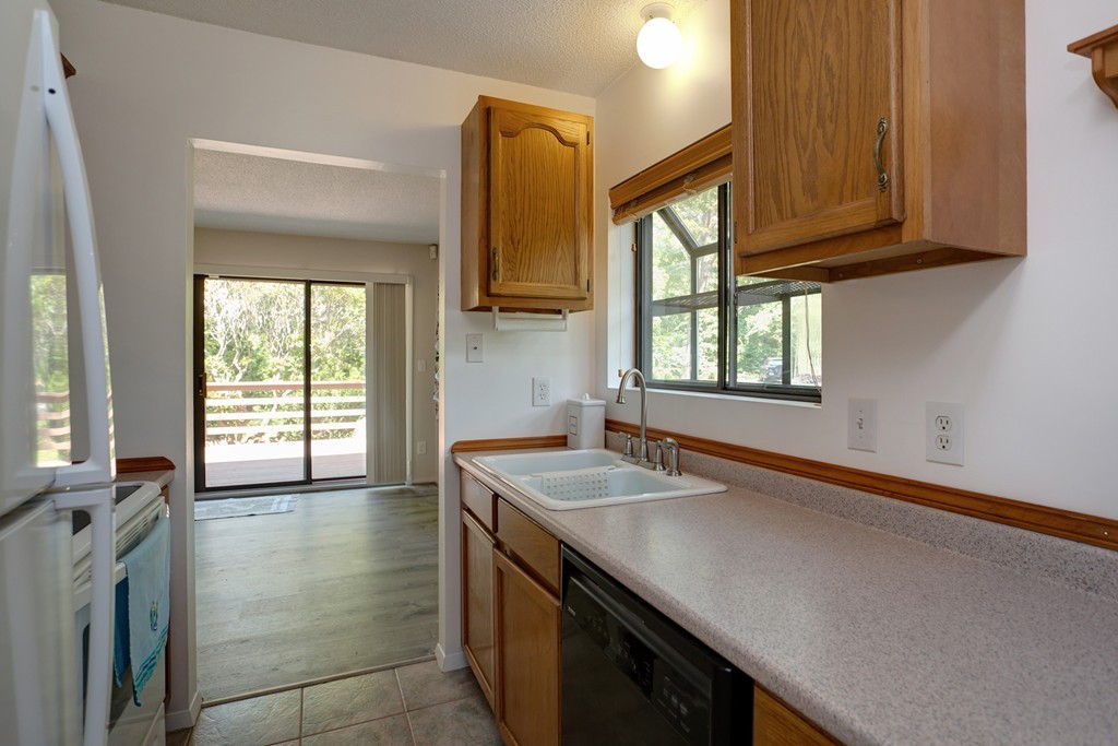 20 Round House Road, Unit 20 Bourne, MA 02532 - Photo 15 of 22 a kitchen with a sink a stove cabinets and a wooden floor