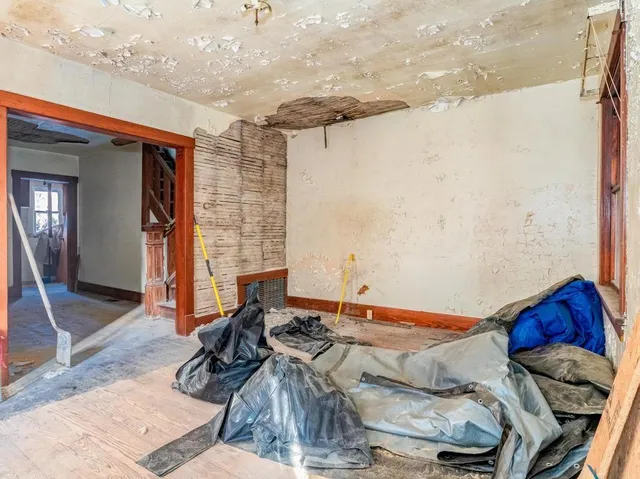 a bed sitting in a bedroom next to a window and a chandelier