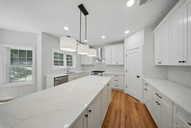 a kitchen with a sink a counter top space stainless steel appliances and cabinets