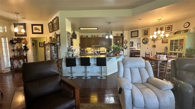 a view of a dining room with furniture a chandelier and wooden floor