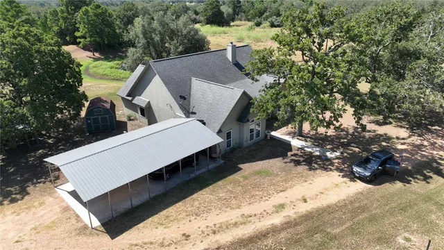 an aerial view of a house with a yard and sitting area