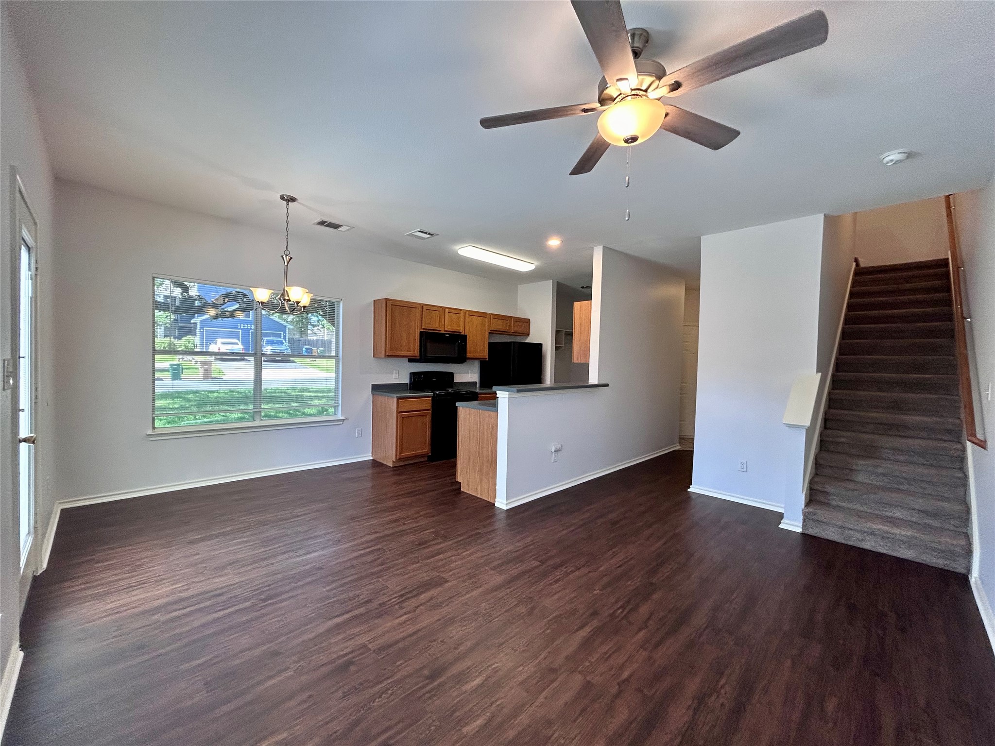 12307 Abney Drive Austin, TX 78729 - Photo 18 of 18 a view of an empty room with wooden floor a ceiling fan and a kitchen