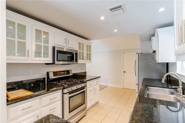 a kitchen with stainless steel appliances kitchen island granite countertop a stove and a sink