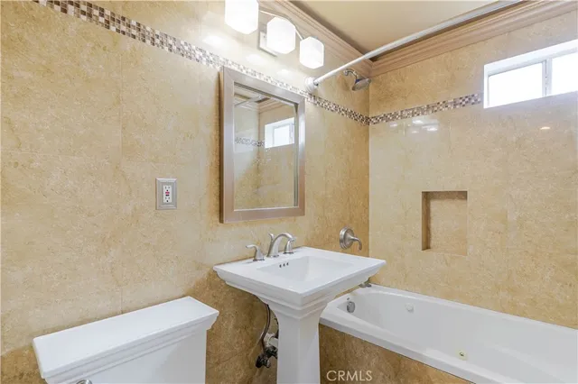 a bathroom with a sink a toilet and a mirror