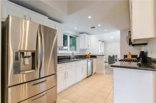 a kitchen with a refrigerator a sink and cabinets