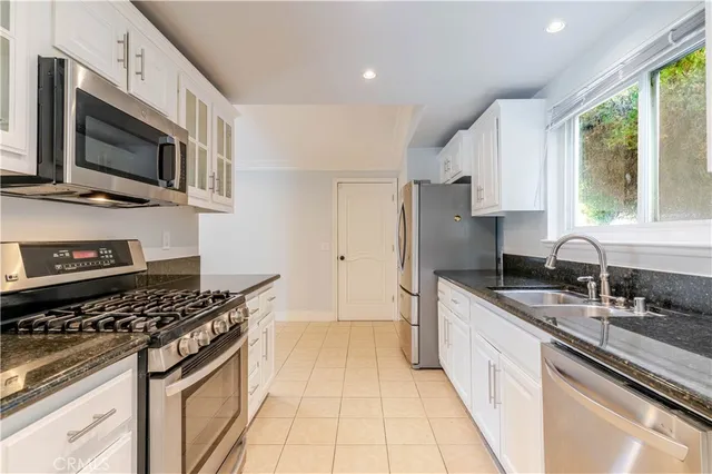 a kitchen with stainless steel appliances a sink stove and microwave