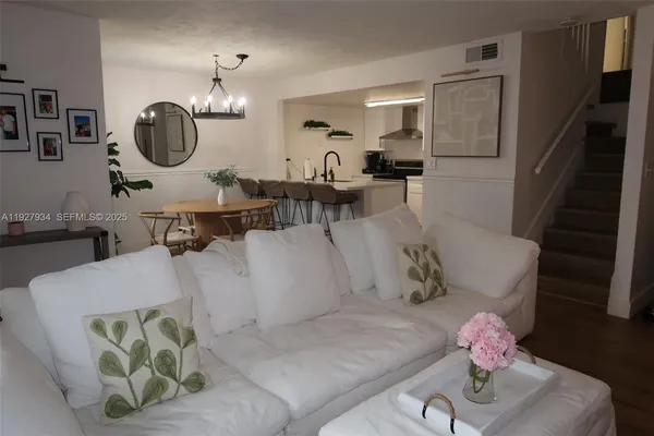 a living room with furniture flowerpot and a mirror