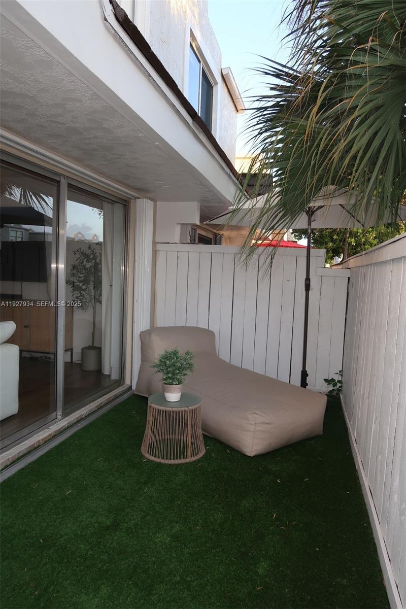 4530 Southwest 68th Ct Circle, Unit 356 Miami, FL 33155 - Photo 15 of 31 a view of a backyard with table and chairs and wooden fence