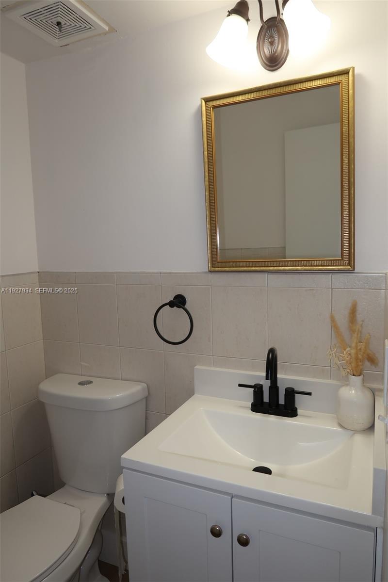 4530 Southwest 68th Ct Circle, Unit 356 Miami, FL 33155 - Photo 29 of 31 a bathroom with a toilet a sink and mirror