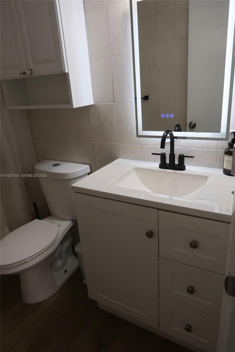 4530 Southwest 68th Ct Circle, Unit 356 Miami, FL 33155 - Photo 31 of 31 a bathroom with a granite countertop toilet sink and mirror