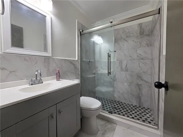 a bathroom with a sink toilet a mirror and shower