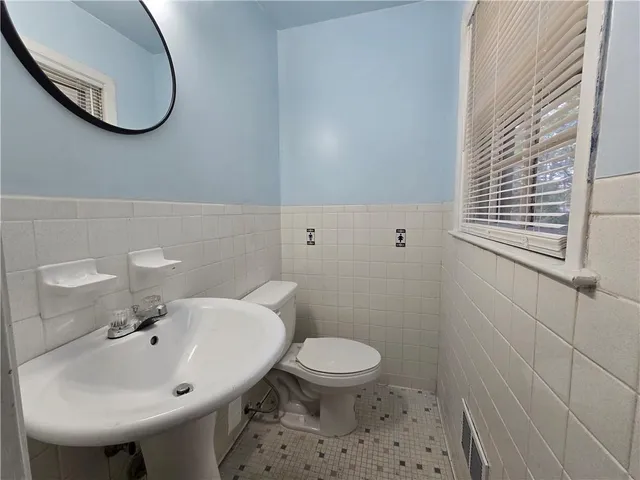 a bathroom with a sink a toilet and a mirror