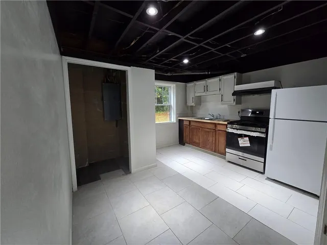 a large kitchen with stainless steel appliances granite countertop a refrigerator and a stove top oven