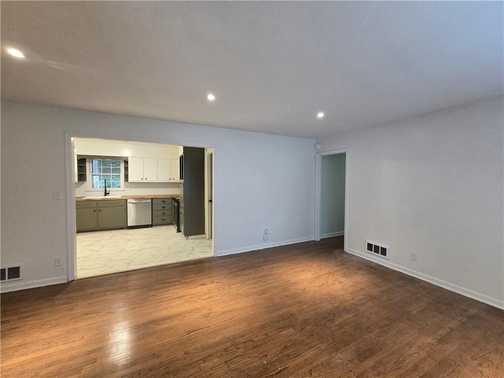2468 Dresden Drive Northeast Atlanta, GA 30341 - Photo 4 of 26 an empty room with wooden floor and a fireplace