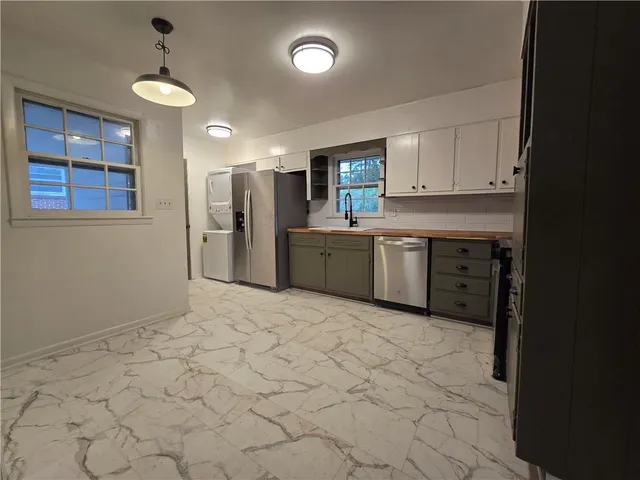 a kitchen with stainless steel appliances granite countertop a refrigerator and a stove top oven