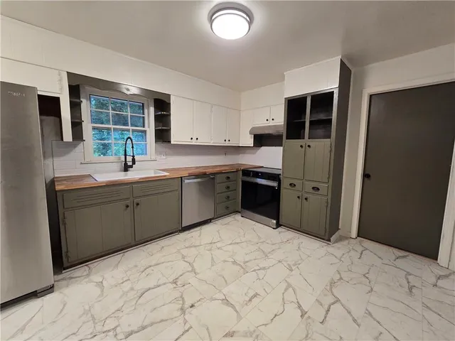 a kitchen with stainless steel appliances granite countertop a sink and cabinets