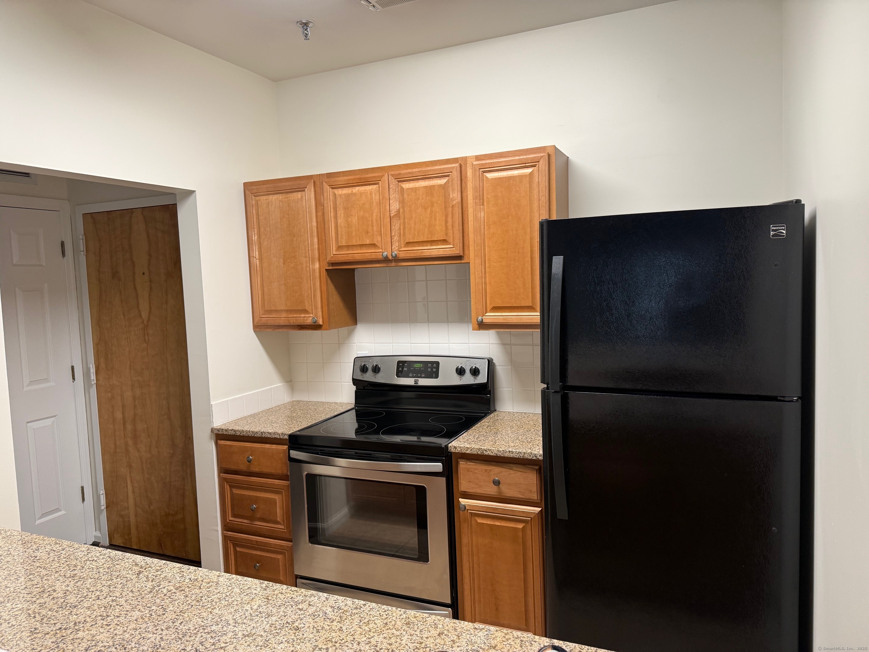 a kitchen with a refrigerator and a stove