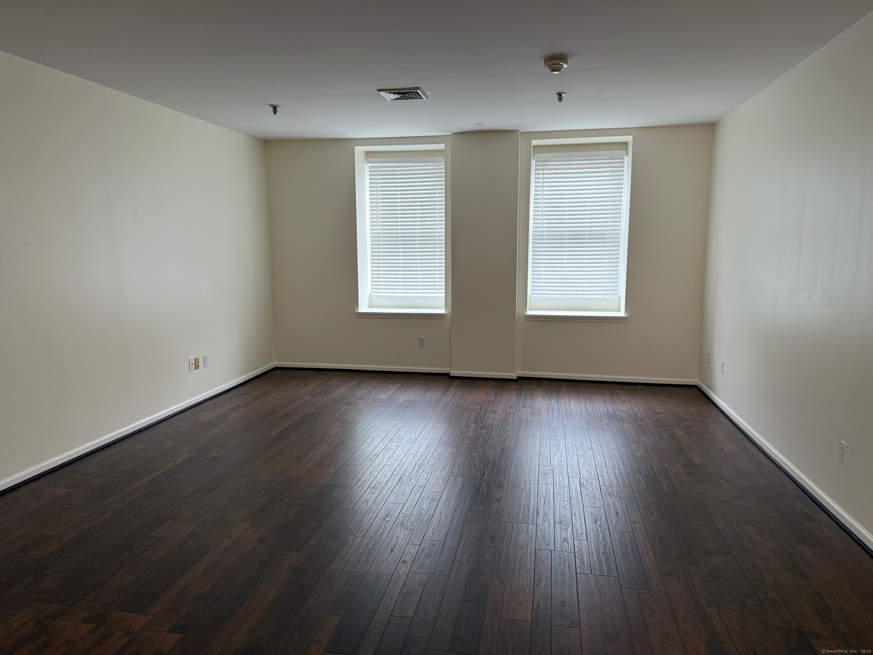 84 Wall Street Norwalk, CT 06850 - Photo 2 of 5 an empty room with wooden floor and windows