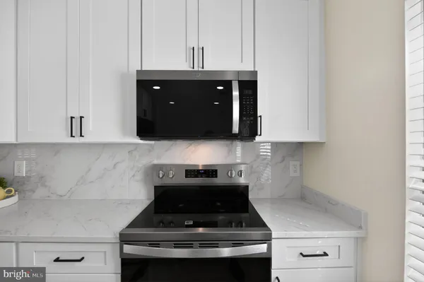 a kitchen with a stove and a white cabinets