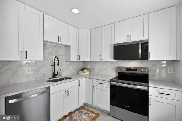 a kitchen with white cabinets and stainless steel appliances
