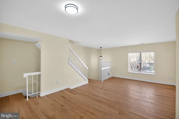 an empty room with wooden floor and window