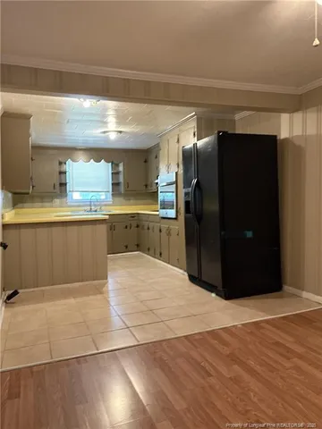 a kitchen with stainless steel appliances kitchen island granite countertop a refrigerator and a sink
