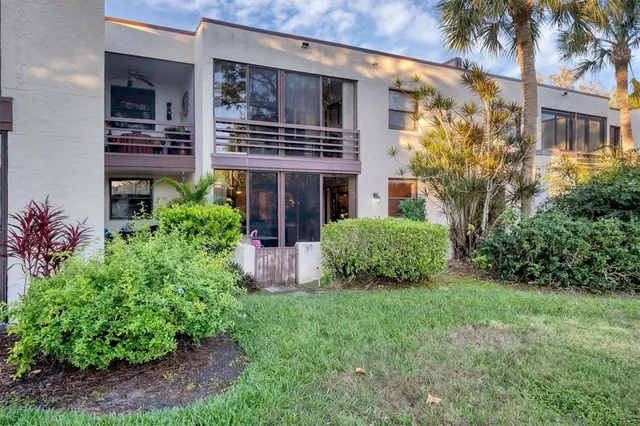 a view of a house with brick walls and a yard with plants