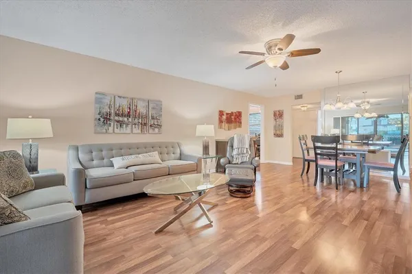 a living room with furniture and a view of kitchen