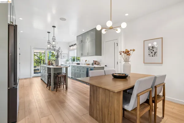 a dining room with wooden floor a chandelier a wooden table and chairs
