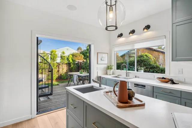 a kitchen with a sink stove and wooden floor