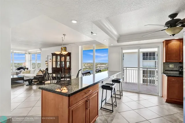 a living room with stainless steel appliances granite countertop a couch and a view of living room