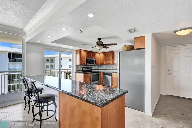 a kitchen with stainless steel appliances granite countertop a refrigerator a stove and a sink
