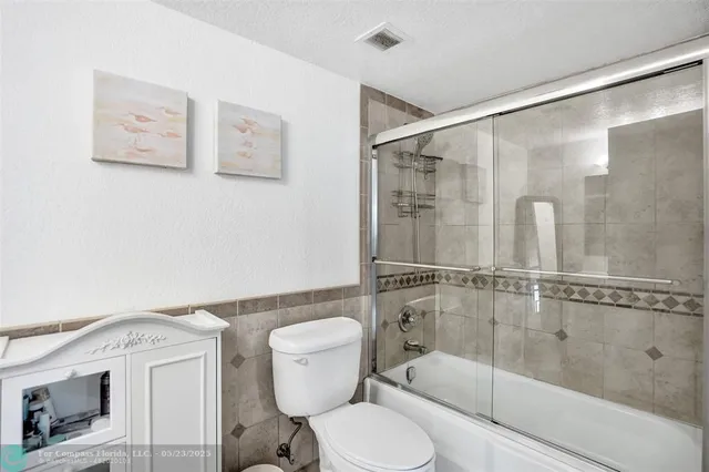 a bathroom with a shower a toilet and a sink