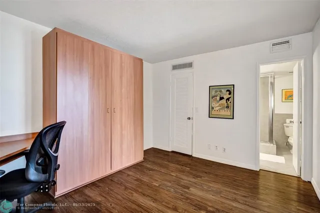 a view of empty room with wooden floor