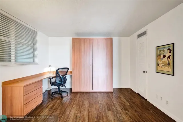 a view of a workspace with furniture and a window