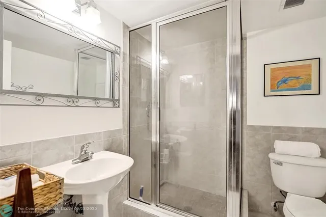 a bathroom with a sink mirror toilet and shower
