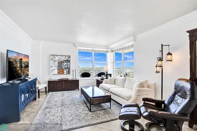 a living room with furniture a rug a window and a flat screen tv