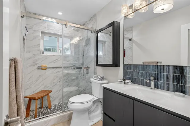 a bathroom with a sink a toilet and shower