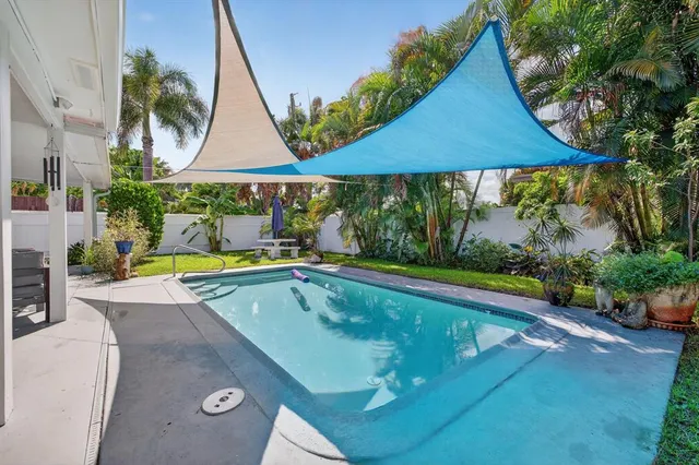 a view of swimming pool and dinning table and chairs under an umbrella