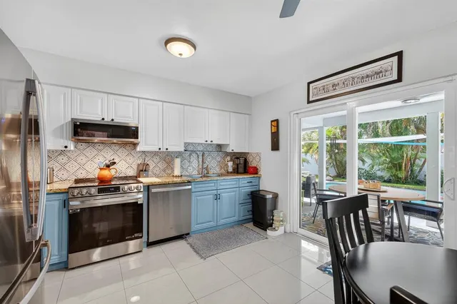 a kitchen that has a stove a sink a oven a dining table and chairs
