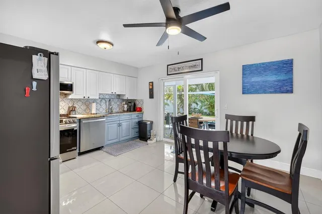 a kitchen with a table chairs refrigerator and cabinets