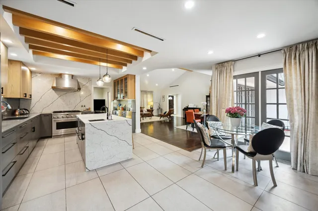 a living room with furniture a dining table and a chandelier