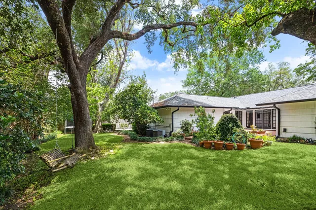 a view of an house with backyard space and tree