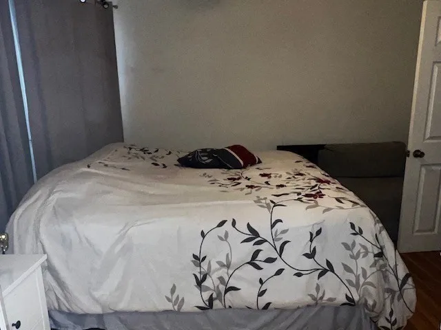 a bed sitting in a bedroom next to a window