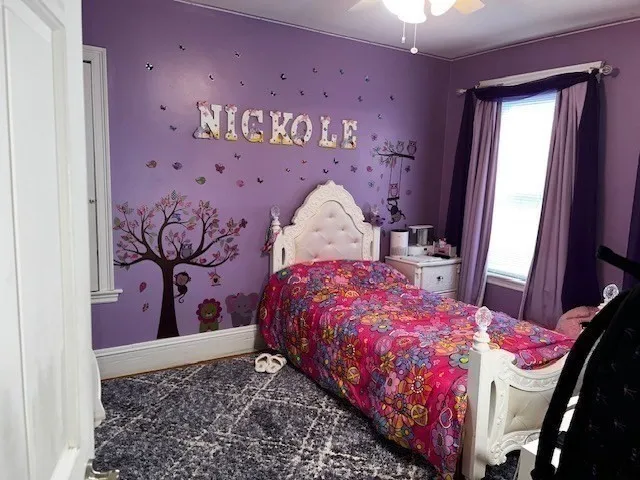 a bedroom with a bed dresser and a window