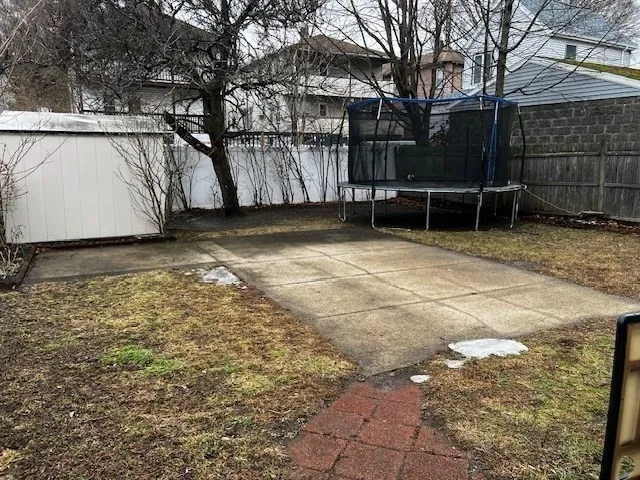 a view of backyard with wooden fence