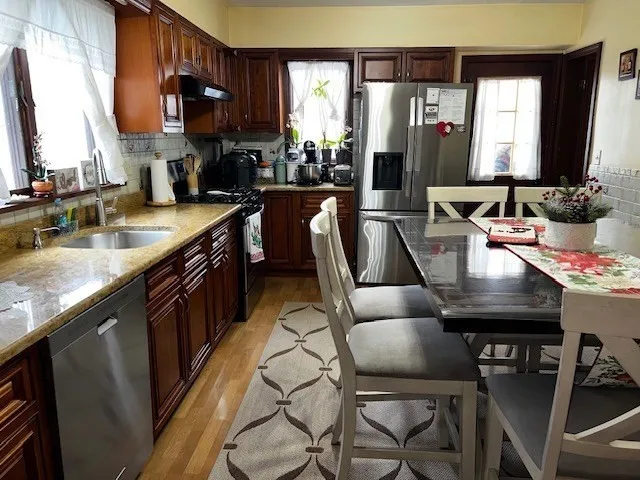 a kitchen with kitchen island granite countertop a sink chairs and cabinets