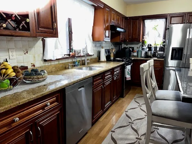 a kitchen with stainless steel appliances granite countertop a sink dishwasher stove and refrigerator